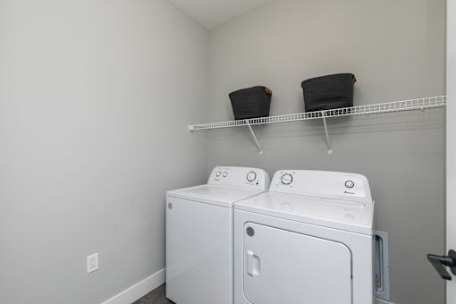A white washer and dryer in a laundry room. at The Cunningham Apartments, Iowa, 50266