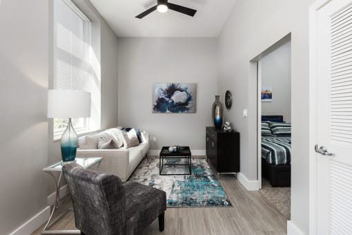 living room with plank flooring, ceiling fan and large windows at The Residences at Delmar DivINe, Missouri, 63112