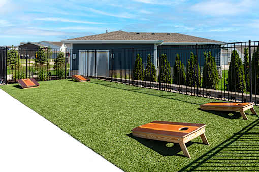 A backyard with a lawn, a fence, and a shed.