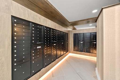 A row of black mailboxes are lined up on a wall at The Cunningham Apartments, Apartments, West Des Moines, IA