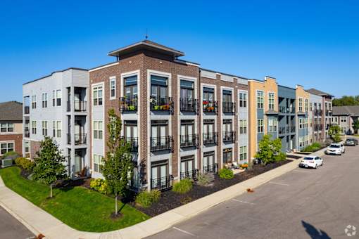 Modern townhome building with balconies and street view at GrandView Flats and Townhomes Apartments, Granger, Indiana