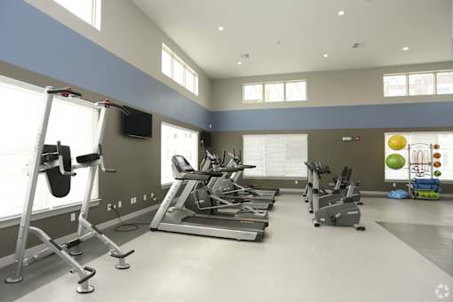 A gym with treadmills, elliptical machines, and other exercise equipment.