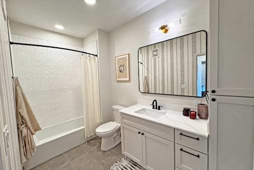 A bathroom with a toilet, sink, and bathtub.