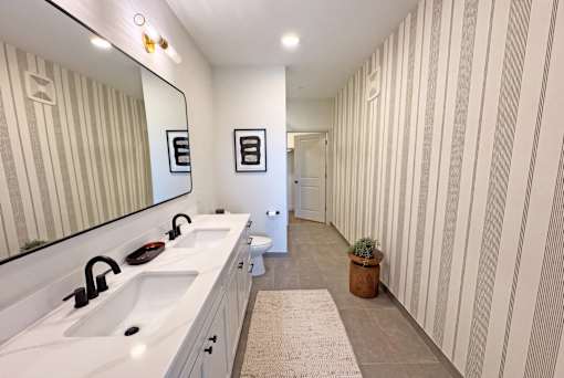 A bathroom with a sink, mirror, and toilet.
