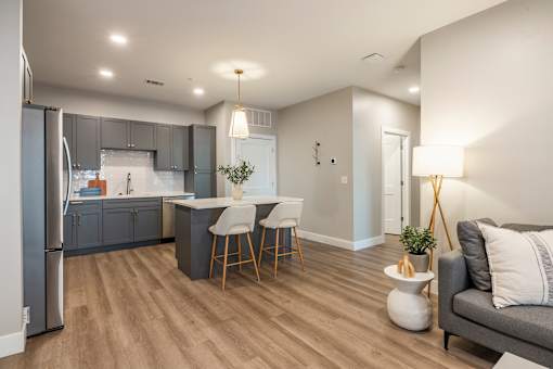 A modern kitchen with a refrigerator, bar stools, and a dining area.at Preserve at Sycamore Creek, Osage Beach, MO 65065