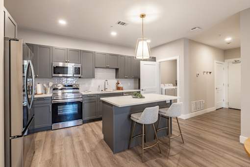 A modern kitchen with a large island and stainless steel appliances.at Preserve at Sycamore Creek, Osage Beach, MO