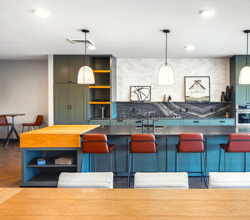 a large kitchen with blue cabinets and a table with chairs at The Rail, St. Louis, MO 63110