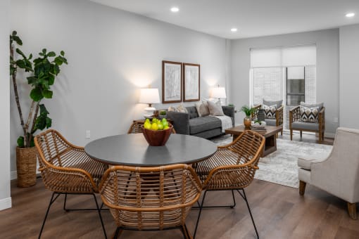 dining area with circular table, seating for 4 with living room in background at The Flats & Terraces at Wildhorse Village, Chesterfield, MO