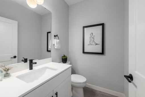 an empty bathroom with a sink and a toilet at The Flats & Terraces at Wildhorse Village, Chesterfield