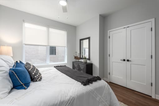 a bedroom with a large bed and a window at The Flats & Terraces at Wildhorse Village, Chesterfield, MO
