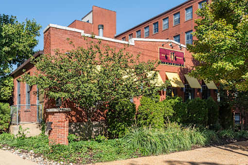 A red brick building with a sign at Lofts at Lafayette Square Apartments, Saint Louis