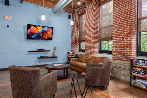 A living room with a couch, chair, and television at Lofts at Lafayette Square Apartments, Saint Louis, MO, 63104