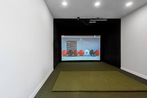 A projection screen in a dark room with a green carpet.