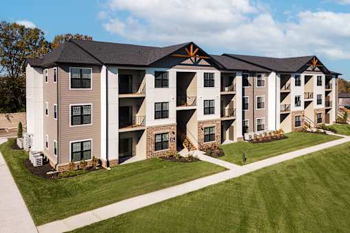 A large apartment complex with multiple balconies and a well-maintained lawn.
