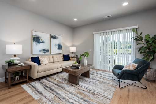 A living room with a beige couch, a wooden coffee table, and a rug.