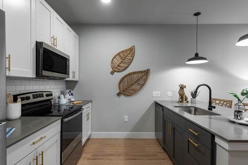 A modern kitchen with a black stove top oven and white cabinets.