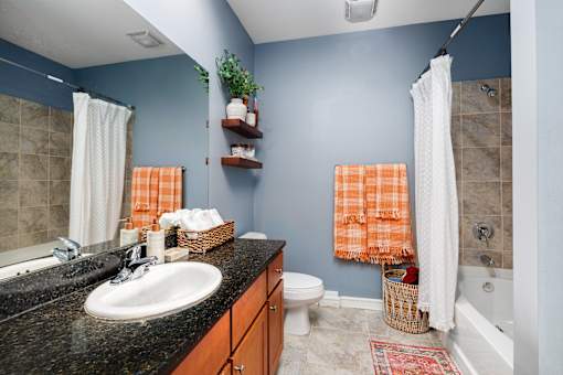 A bathroom with a white sink and a white toilet.