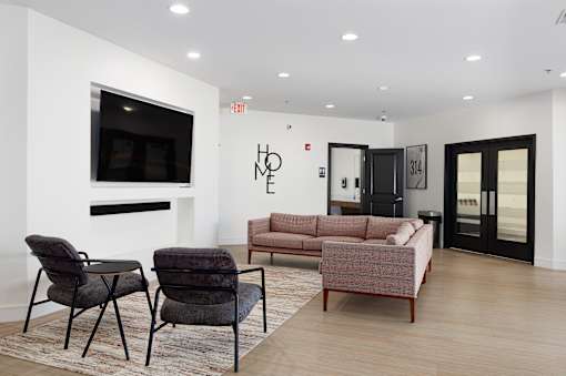 A living room with a fireplace, a couch, a chair, and a television.
