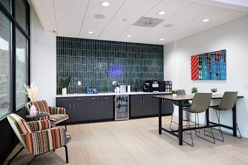 A modern office with a glass wall and a bar area.