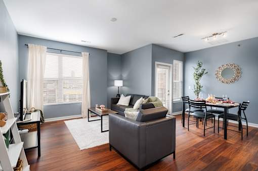 A living room with a grey sofa and a dining table set for six.
