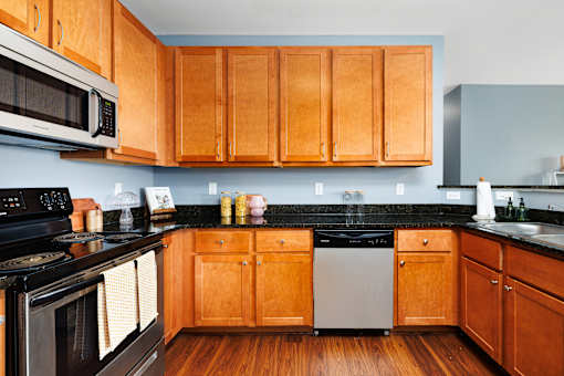 A kitchen with wooden cabinets and black appliances.