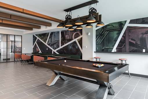A pool table is in the middle of the room.