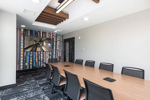 A conference room with a long table and chairs.