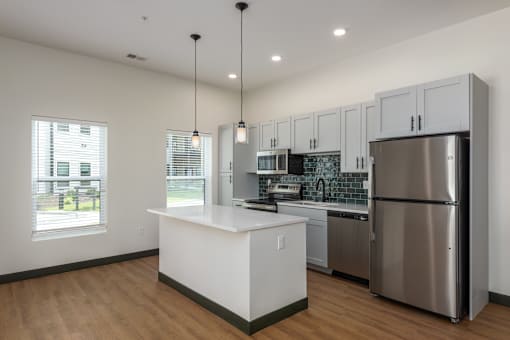 A modern kitchen with stainless steel appliances and white cabinetry.