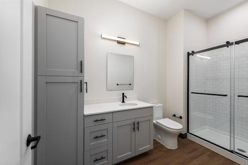 A bathroom with a sink, toilet, and shower.
