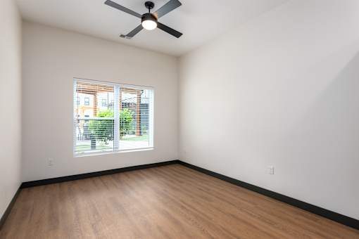 A room with a ceiling fan and a window.