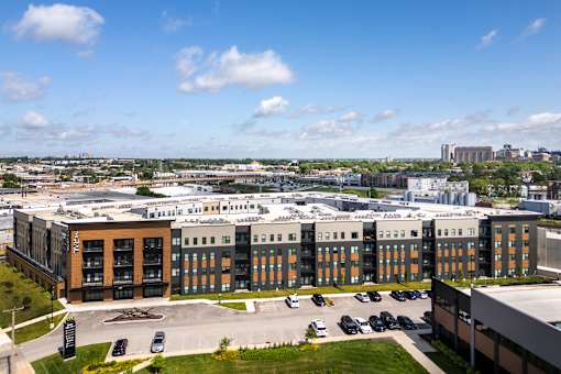 A large building complex with a parking lot in front.