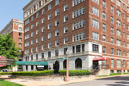 A large red brick building with a green awning in front.