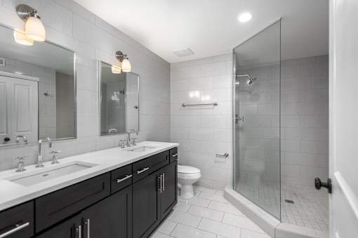 York House design bathroom with quartz countertops, oversized custom shower with glass doors and floor-to-ceiling tile.