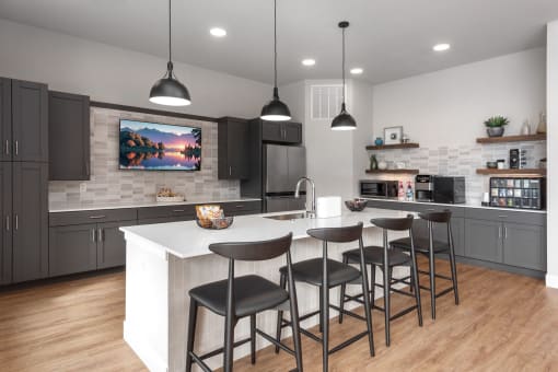 a kitchen with a large island with four stools in front of a counter top at The Station St. Peters, St. Peters, MO 63376