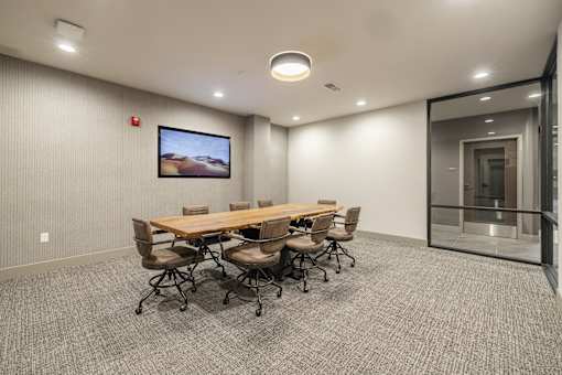 A conference room with a long table and chairs.
