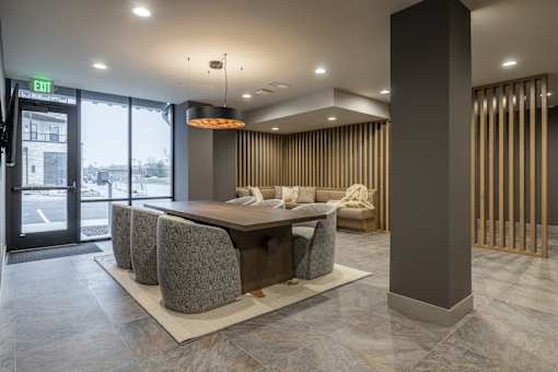 A modern office lobby with a reception desk and chairs.