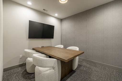 A conference room with a long table and chairs.