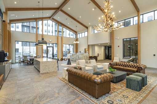 A large, well-lit living room with a variety of seating options and a chandelier.