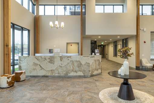 A reception area with a stone counter and a black table.