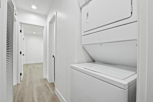 the laundry room of a home with white cabinets and a washer and dryer