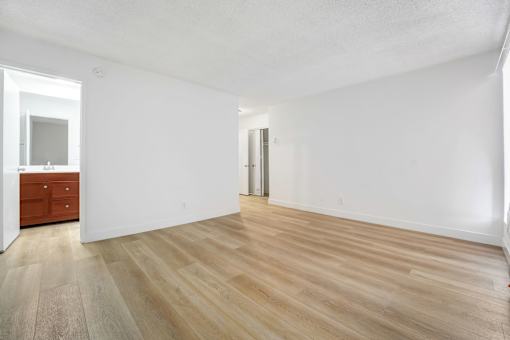 A room with wooden flooring and white walls.