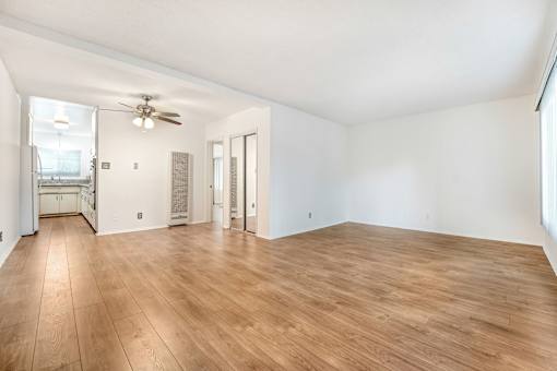 A room with wooden flooring and a ceiling fan.