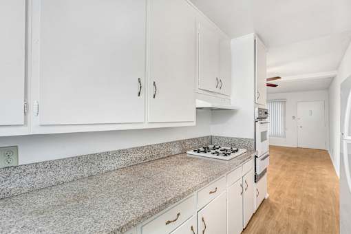 A kitchen with white cabinets and a granite countertop.