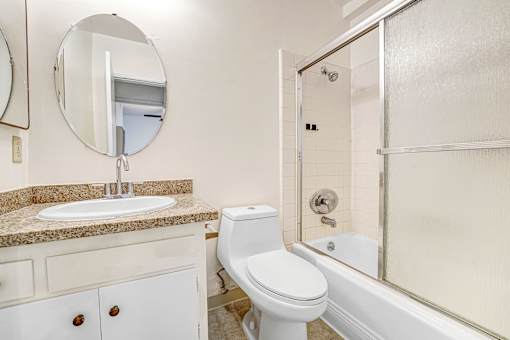 A white toilet sits next to a sink in a bathroom.