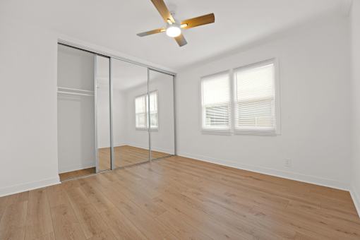 A room with a ceiling fan and a sliding door.