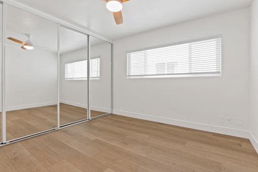 A room with a ceiling fan and a glass wall.