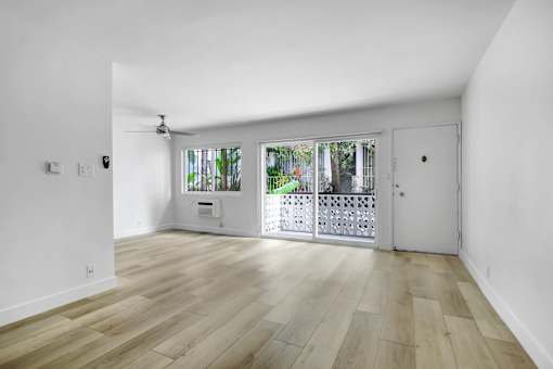 A room with wooden flooring and a ceiling fan.