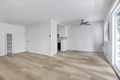 A room with wooden flooring and a ceiling fan.