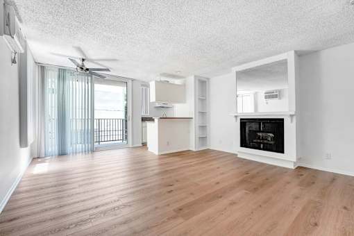 A spacious living room with a fireplace and a sliding glass door.