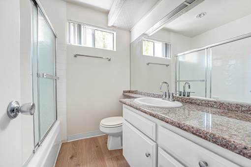 A bathroom with a toilet, sink, and shower.
